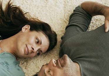 couple laying on warm carpet